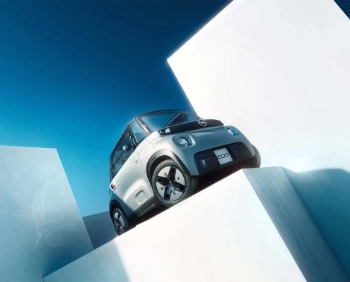 Električni štirikolesnik Opel Rocks v svetlo sivi barvi z novo črno masko Vizor in belim logotipom Blitz, predstavljen kot sodobno urbano vozilo za mlade. (David Magazine for Men with Style) / Opel Rocks electric quadricycle in light grey with new black Vizor grille and white Blitz logo, introduced as a modern urban mobility solution for youth. (David Magazine for Men with Style)