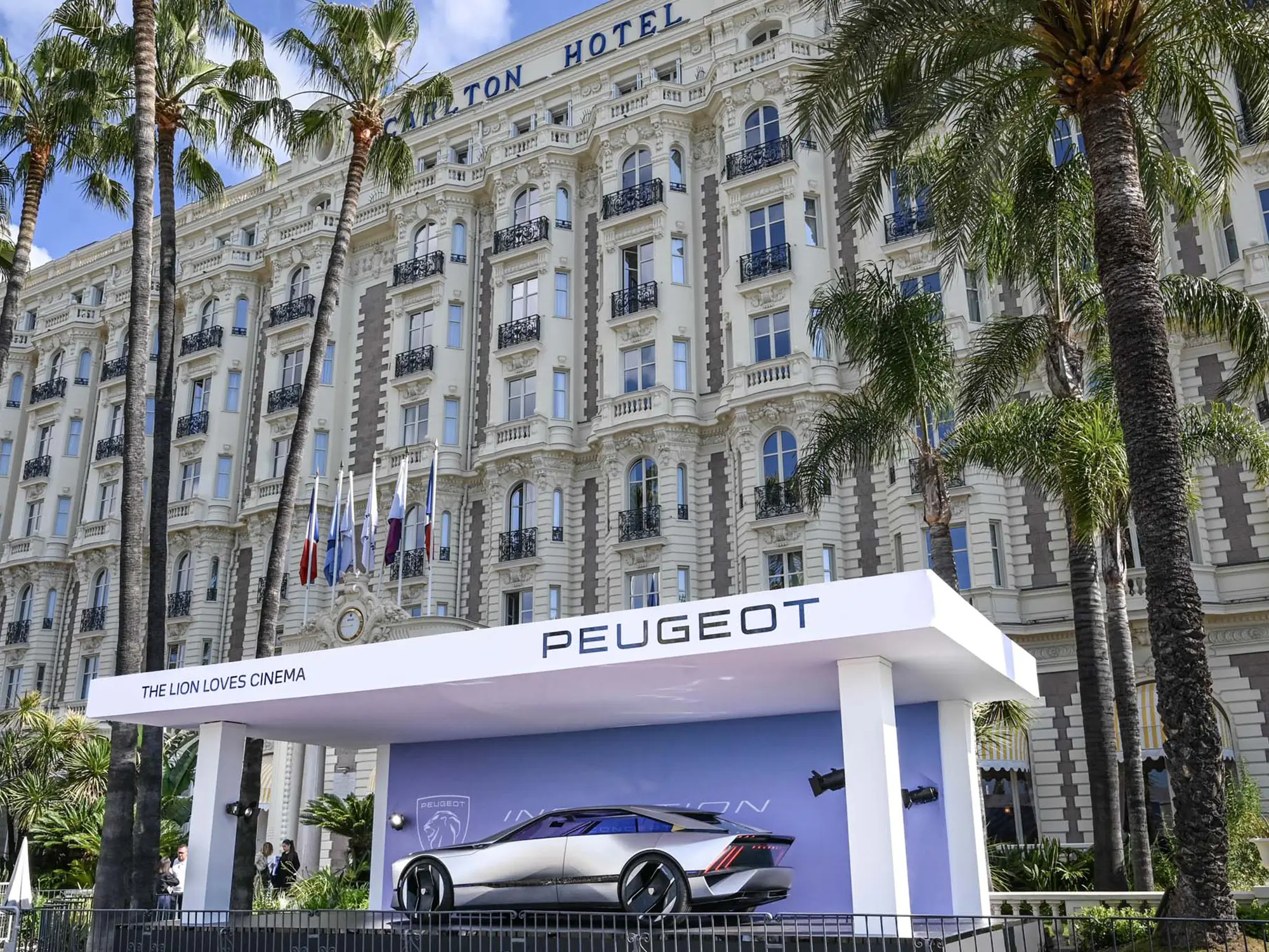 Koncept Peugeot Inception pred hotelom Carlton v Cannesu med filmskim festivalom, prikazan kot simbol povezave med avtomobilsko prihodnostjo in francoskim filmom. (David Magazine for Men with Style) / Peugeot Inception concept car in front of the Carlton Hotel in Cannes during the film festival, symbolizing the brand’s commitment to cinema and future mobility. (David Magazine for Men with Style)
