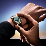 Ura Rolex Oyster Perpetual Cosmograph Daytona z ledeno modro številčnico, kronografskimi števci in 18-karatnim zlatim ohišjem, na črnem Oysterflex paščku – fotografirano v zlati svetlobi sončnega zahoda. (David Magazine for Men with Style) / Rolex Oyster Perpetual Cosmograph Daytona with an ice blue dial, chronograph counters, and 18k gold case on a black Oysterflex strap – photographed in golden sunset light. (David Magazine for Men with Style)