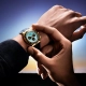 Ura Rolex Oyster Perpetual Cosmograph Daytona z ledeno modro številčnico, kronografskimi števci in 18-karatnim zlatim ohišjem, na črnem Oysterflex paščku – fotografirano v zlati svetlobi sončnega zahoda. (David Magazine for Men with Style) / Rolex Oyster Perpetual Cosmograph Daytona with an ice blue dial, chronograph counters, and 18k gold case on a black Oysterflex strap – photographed in golden sunset light. (David Magazine for Men with Style)