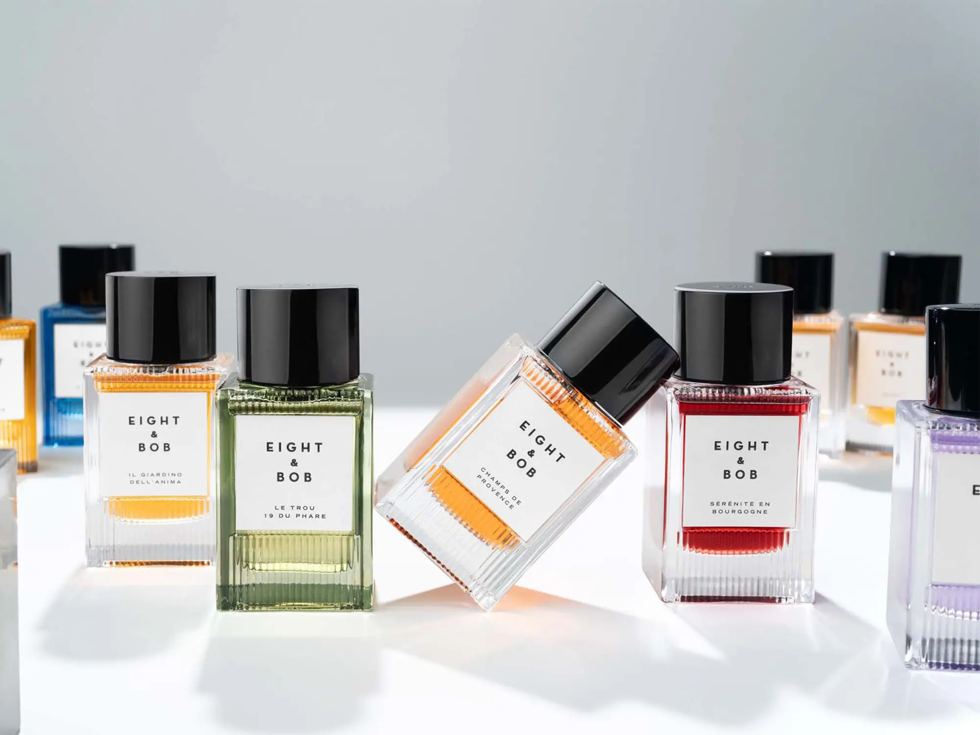 Unisex parfumi Eight & Bob – kolekcija FOUQUET z elegantno artdeko embalažo in barvitimi stekleničkami v minimalistični postavitvi. (David Magazine for Men with Style) / Eight & Bob unisex perfumes – FOUQUET collection featuring elegant art deco packaging and colorful bottles in a minimalist arrangement. (David Magazine for Men with Style)