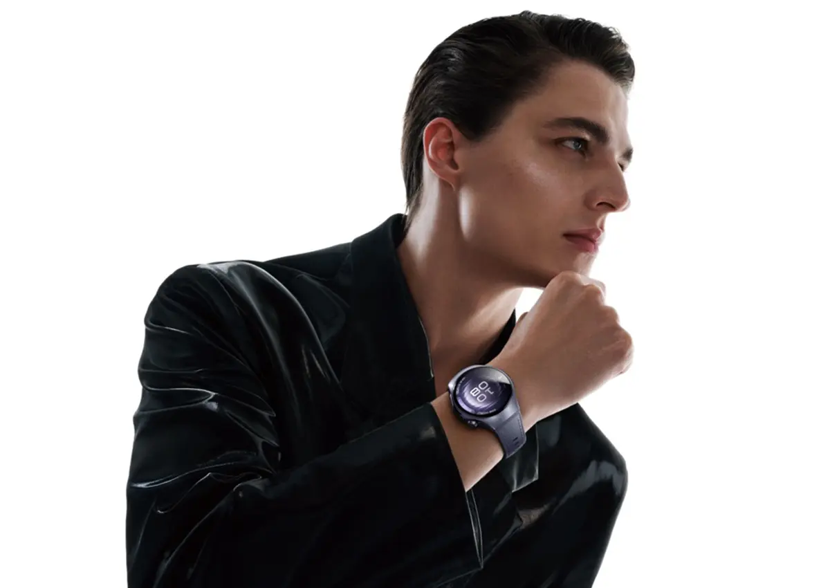 Moški v elegantni črni opravi z novo pametno uro Huawei Watch na zapestju, ob belem ozadju. (David Magazine for Men with Style) / A man in a sleek black outfit wearing the new Huawei Watch on his wrist against a white background. (David Magazine for Men with Style)