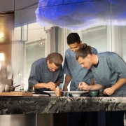 Kuharska ekipa The Cloud by Käfer s kuharskim mojstrom Jensom Madsenom med pripravo jedi v vrhunski restavraciji BMW Welt v Münchnu. (David Magazine for Men with Style) / The culinary team of The Cloud by Käfer, led by head chef Jens Madsen, preparing dishes in the fine dining restaurant at BMW Welt, Munich. (David Magazine for Men with Style)