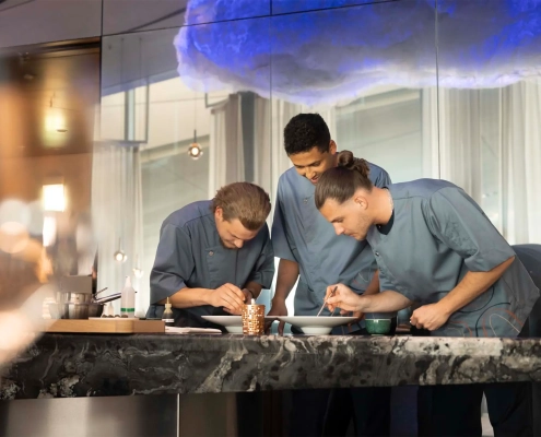 Kuharska ekipa The Cloud by Käfer s kuharskim mojstrom Jensom Madsenom med pripravo jedi v vrhunski restavraciji BMW Welt v Münchnu. (David Magazine for Men with Style) / The culinary team of The Cloud by Käfer, led by head chef Jens Madsen, preparing dishes in the fine dining restaurant at BMW Welt, Munich. (David Magazine for Men with Style)