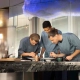 Kuharska ekipa The Cloud by Käfer s kuharskim mojstrom Jensom Madsenom med pripravo jedi v vrhunski restavraciji BMW Welt v Münchnu. (David Magazine for Men with Style) / The culinary team of The Cloud by Käfer, led by head chef Jens Madsen, preparing dishes in the fine dining restaurant at BMW Welt, Munich. (David Magazine for Men with Style)