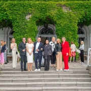 Skupina gostov na stopnišču gradu Leopoldskron na tiskovni konferenci pred prvim amfAR Gala Salzburg 2025; med njimi Gery Keszler, Arabel von Karajan, Elisabeth Gürtler, Marlies Muhr, Marion Pelzl, Elisabeth Friesacher in Mucky Degn. Prispevek revije David – revija za moške s stilom. / Guests gathered on the steps of Schloss Leopoldskron during the press event ahead of the inaugural amfAR Gala Salzburg 2025, including Gery Keszler and other supporters. Featured in David – men's magazine with style.