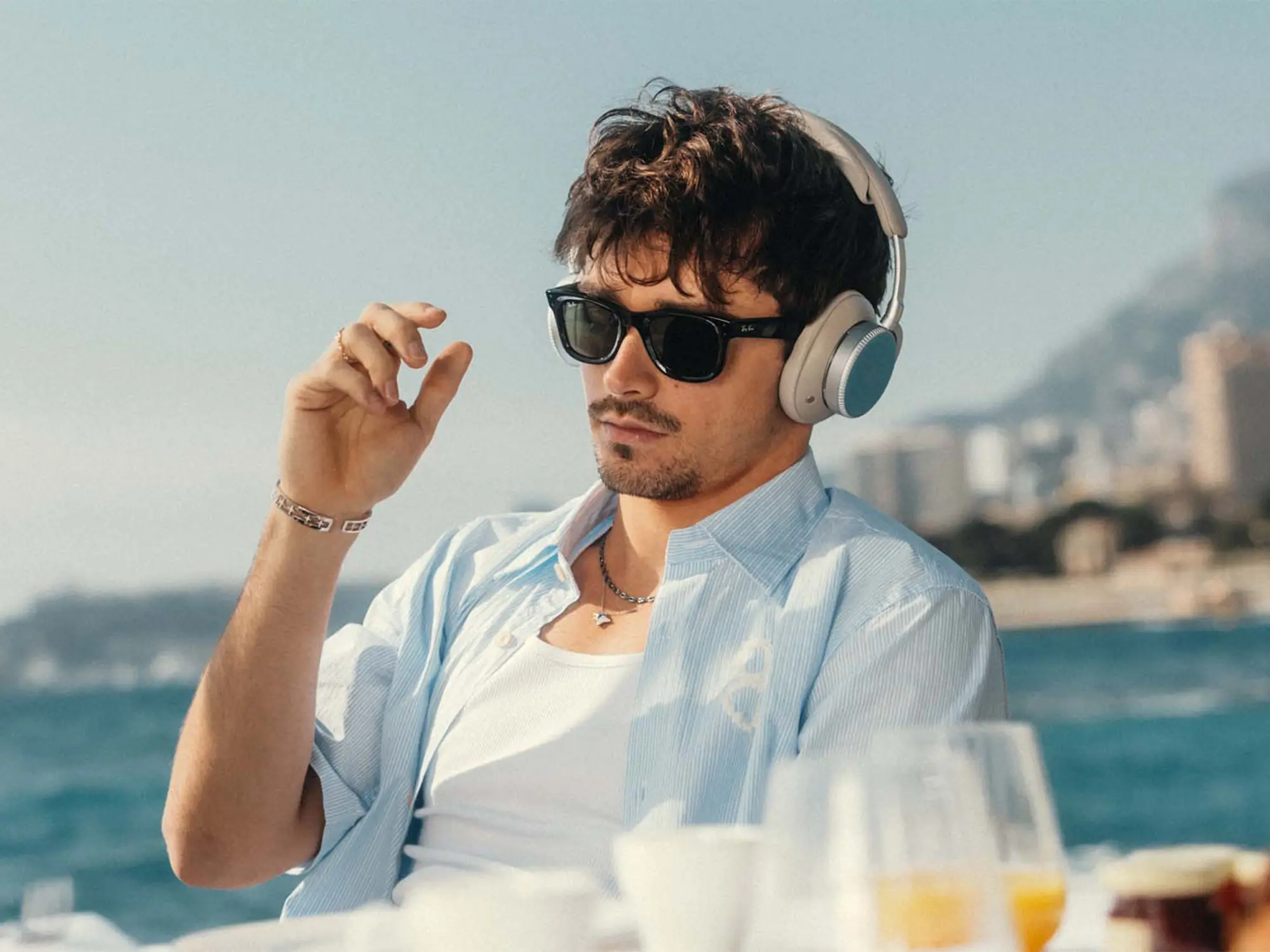 Charles Leclerc z omejeno izdajo slušalk Bang & Olufsen Beoplay H100 – ujet v trenutku sprostitve na obali Monaka. Tehnična dovršenost in oblikovalska eleganca v stilu Davida – revije za moške s stilom. Charles Leclerc wearing the limited-edition Bang & Olufsen Beoplay H100 headphones – captured relaxing on the Monaco coastline. Technical excellence and refined design featured in David magazine for men with style.