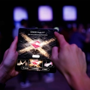 Obiskovalec uporablja zložljivi pametni telefon HONOR Magic V5 med premierno predstavitvijo v Ljubljani – tehnološka eleganca v rokah moškega s stilom. A visitor using the foldable smartphone HONOR Magic V5 during its premiere event in Ljubljana – technological elegance in the hands of a man with style.