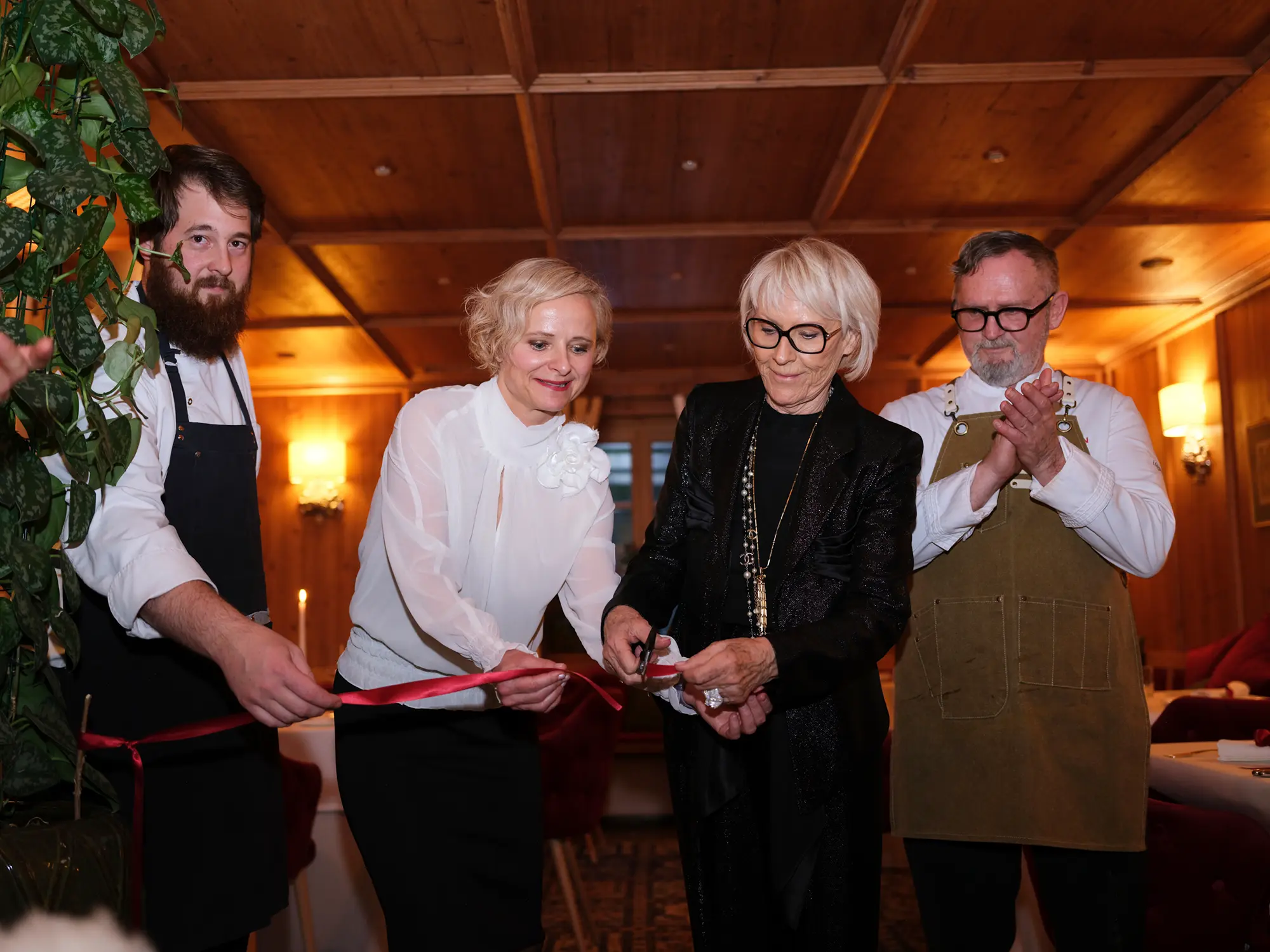 Simboličen trenutek odprtja restavracije Hotela Plesnik z rezanjem traku – ekipa z lastnico, direktorico in chefoma predstavlja trajnostno kulinarično zgodbo z zeleno Michelinovo zvezdico. The ceremonial ribbon cutting at the opening of Hotel Plesnik's restaurant – the team including the owner, director, and chefs unveil a sustainable culinary story awarded with a Green Michelin Star.