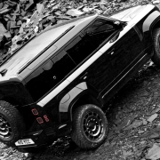 Land Rover Defender OCTA Black Edition med ekstremno terensko vožnjo po kamnitem terenu – luksuzni SUV s karakterjem, predstavljen v reviji David za moške s stilom.