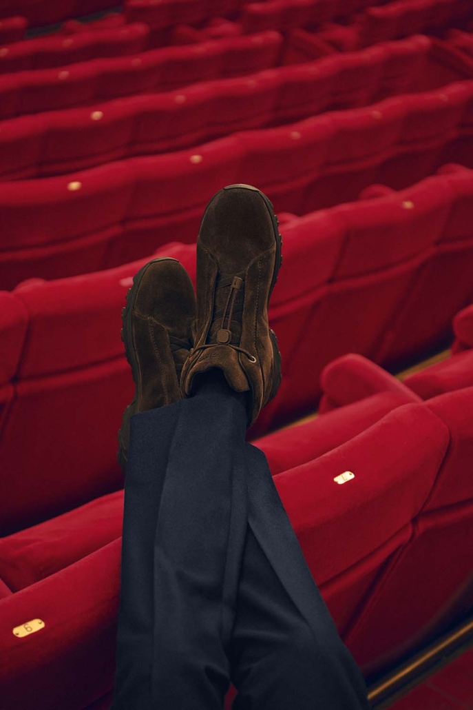 Igralec Mads Mikkelsen oblečen v elegantno pepita vzorčasto ZEGNA obleko, sedi v klasični italijanski kavarni in pije kavo – sofisticirana interpretacija torinskega stila za jesen/zimo 2025.
Actor Mads Mikkelsen wearing an elegant houndstooth ZEGNA suit, seated in a classic Italian café sipping coffee – a sophisticated take on the Turin style for Fall/Winter 2025.