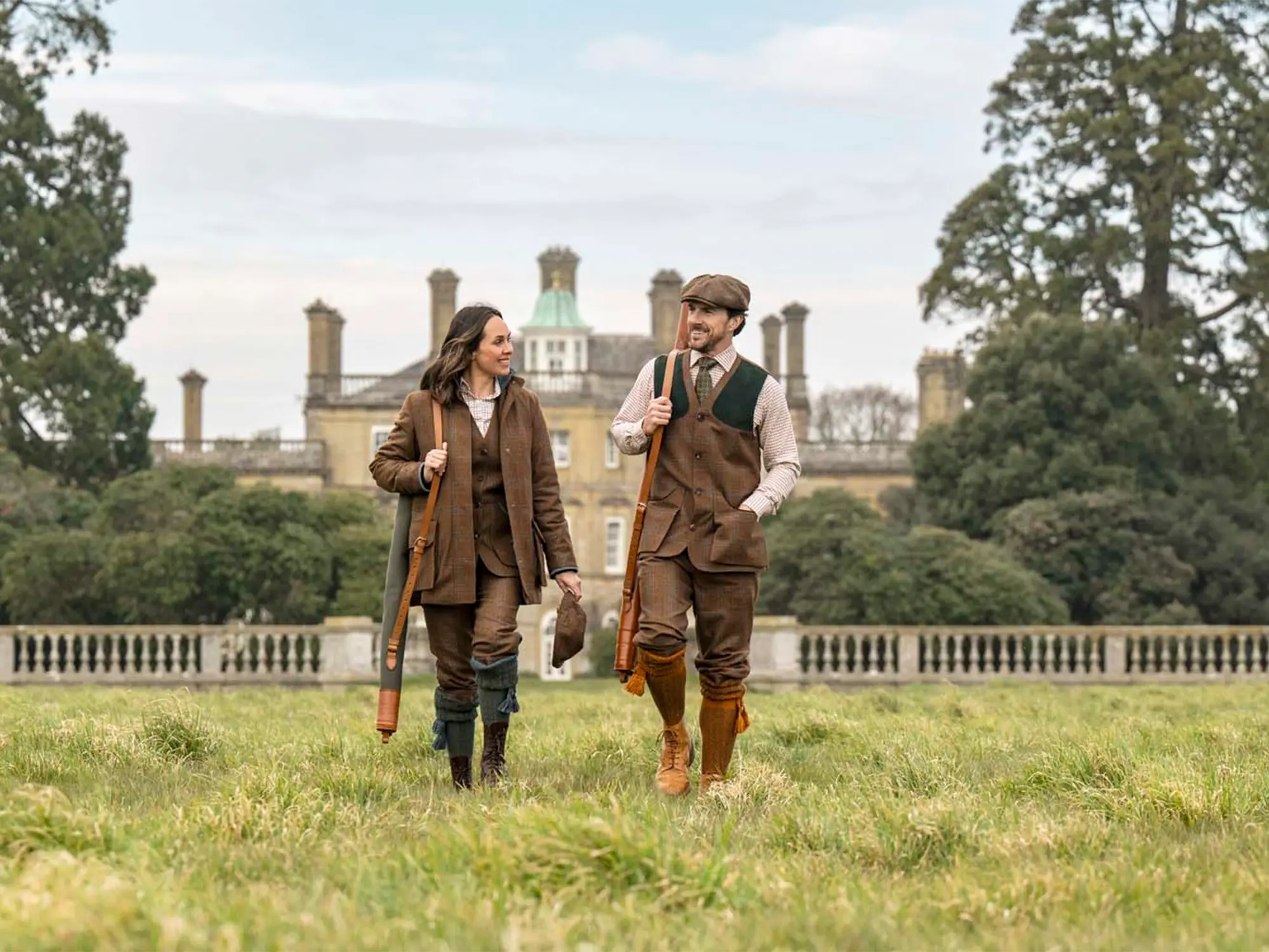 Moški in ženska v elegantnih tvid oblačilih Holland & Holland, med sprehodom po angleškem podeželju.