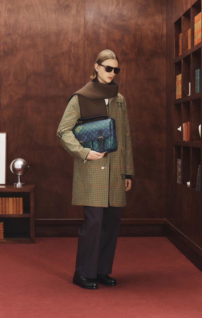 Moški model v karo plašču Louis Vuitton Ivy League 2025 z zeleno torbo Monogram Héritage.