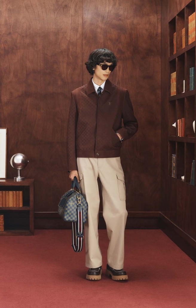 Louis Vuitton Ivy League moška kapsula 2025 – outfit v bordo tonu s karo jakno in torbo Damier.