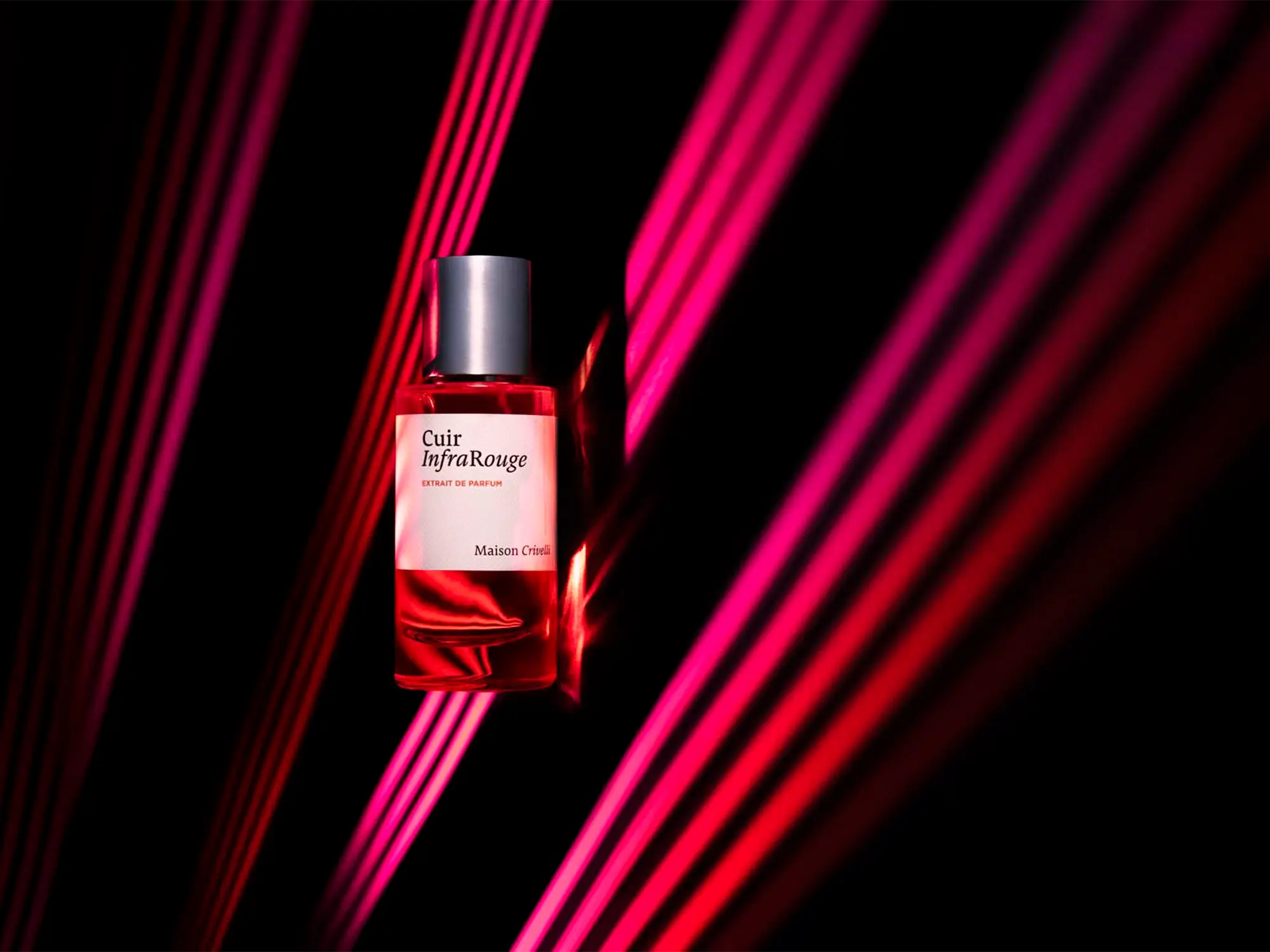 Steklenička parfuma Cuir InfraRouge Maison Crivelli z rožnatimi laserskimi žarki v ozadju