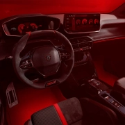 Peugeot E-208 GTi – Električna moč z GTi dušo Notranjost novega Peugeot E-208 GTi s športnim volanom, digitalnimi merilniki in rdečo ambientalno osvetlitvijo.