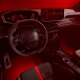 Notranjost novega Peugeot E-208 GTi s športnim volanom, digitalnimi merilniki in rdečo ambientalno osvetlitvijo.