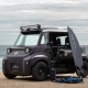 Električni Citroën Ami Buggy Rip Curl parkiran ob obali s surfarsko opremo.