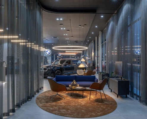 Notranjost novega BMW salona Retail.NEXT v Ljubljani z razstavljenim vozilom in sodobnim lounge ambientom AutoWallis.