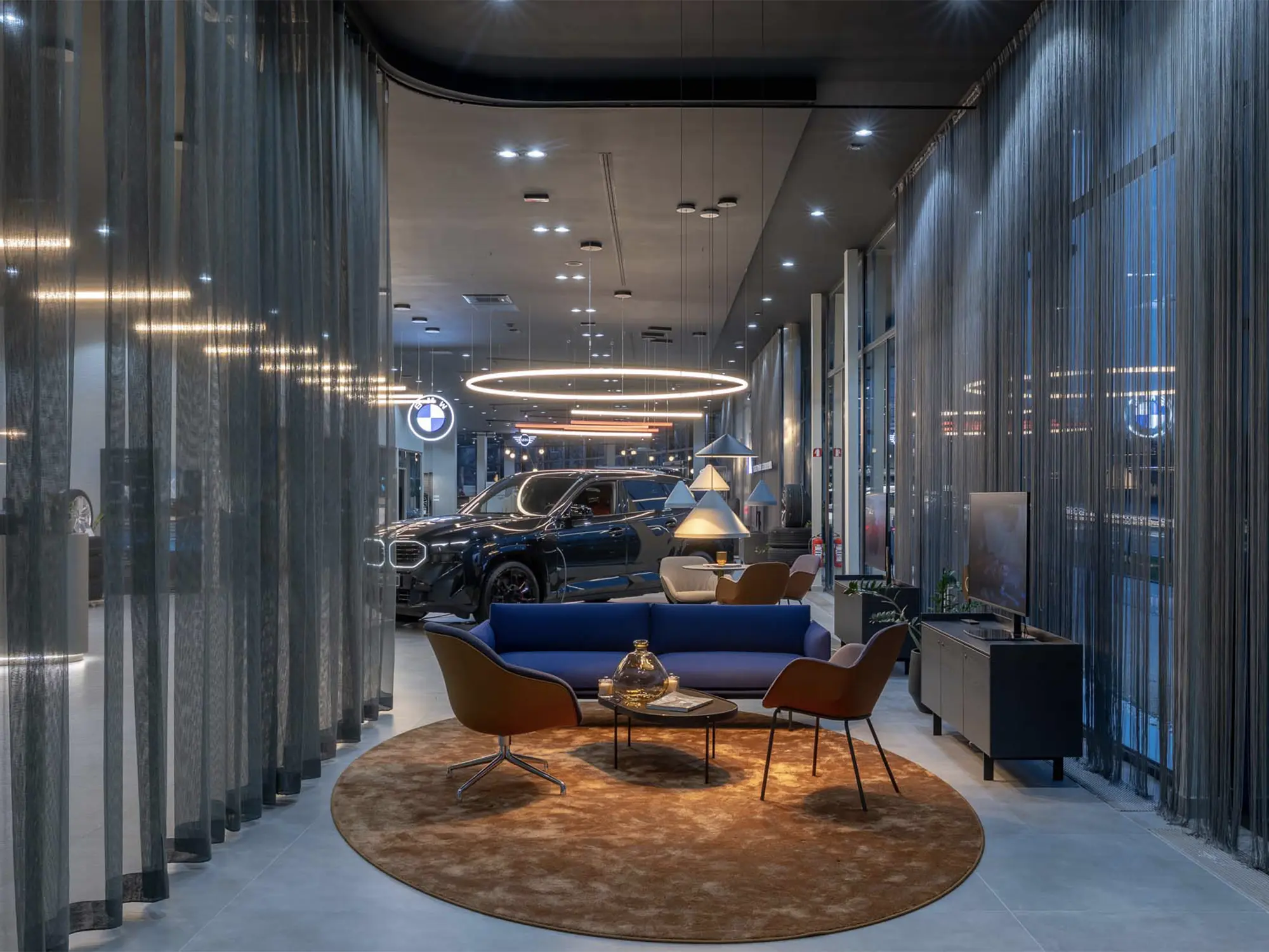 Notranjost novega BMW salona Retail.NEXT v Ljubljani z razstavljenim vozilom in sodobnim lounge ambientom AutoWallis.