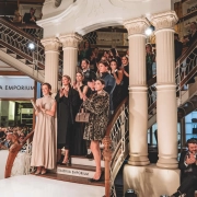 Občinstvo in modeli stojijo na stopnicah zgodovinske stavbe Galerije Emporium med modno revijo ob praznovanju 15-letnice in Meseca italijanske mode.