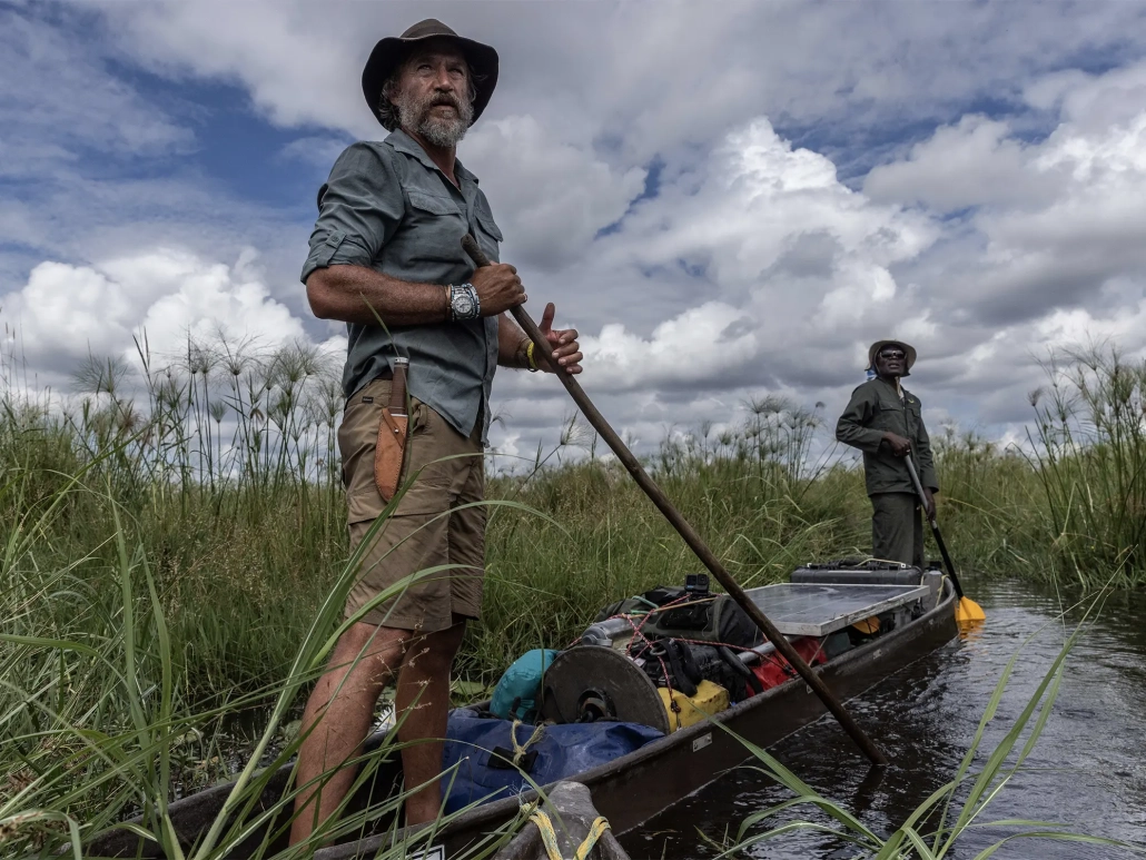 Raziskovalec Steve Boyes med odpravo Great Spine of Africa na reki Zambezi, podprt z iniciativo Rolex Perpetual Planet, stoji v tradicionalnem čolnu sredi angolskega višavja.