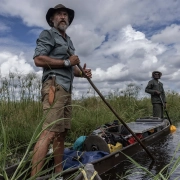 Raziskovalec Steve Boyes med odpravo Great Spine of Africa na reki Zambezi, podprt z iniciativo Rolex Perpetual Planet, stoji v tradicionalnem čolnu sredi angolskega višavja.