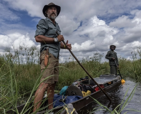 Raziskovalec Steve Boyes med odpravo Great Spine of Africa na reki Zambezi, podprt z iniciativo Rolex Perpetual Planet, stoji v tradicionalnem čolnu sredi angolskega višavja.