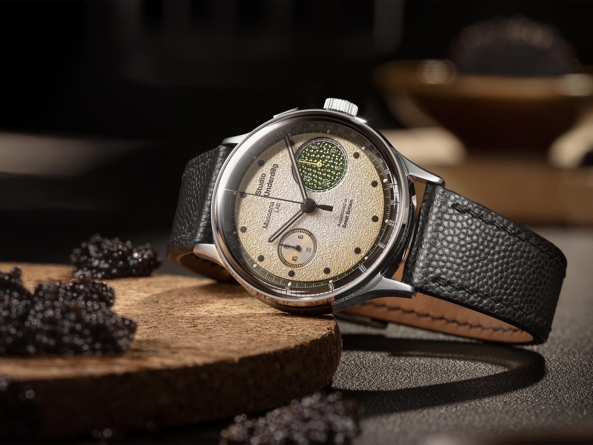 Studio Underd0g x Massena Champagne & Caviar – omejena izdaja kronografa Ura Studio Underd0g x Massena LAB 03SERIES Champagne & Caviar z bež številčnico, zelenim podštevcem in črnim usnjenim paščkom.