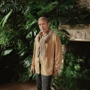 Moški v elegantnem Zegna stilu v zimskem vrtu Oasi Zegna v italijanskih Alpah.