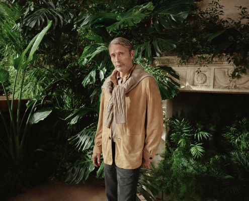 Moški v elegantnem Zegna stilu v zimskem vrtu Oasi Zegna v italijanskih Alpah.