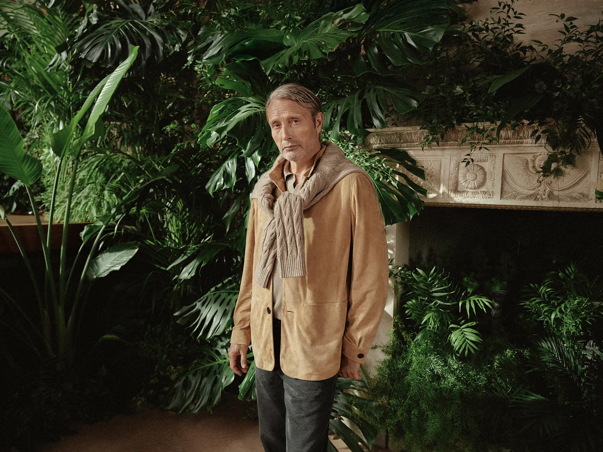 Moški v elegantnem Zegna stilu v zimskem vrtu Oasi Zegna v italijanskih Alpah.