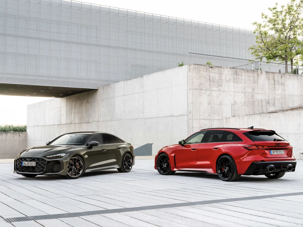 Audi RS 5 v sivi in rdeči barvi, parkiran pred moderno arhitekturo.