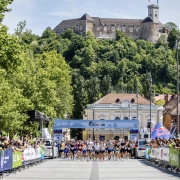 Tekači na startu Wings for Life World Run na Kongresnem trgu v Ljubljani z Ljubljanskim gradom v ozadju.