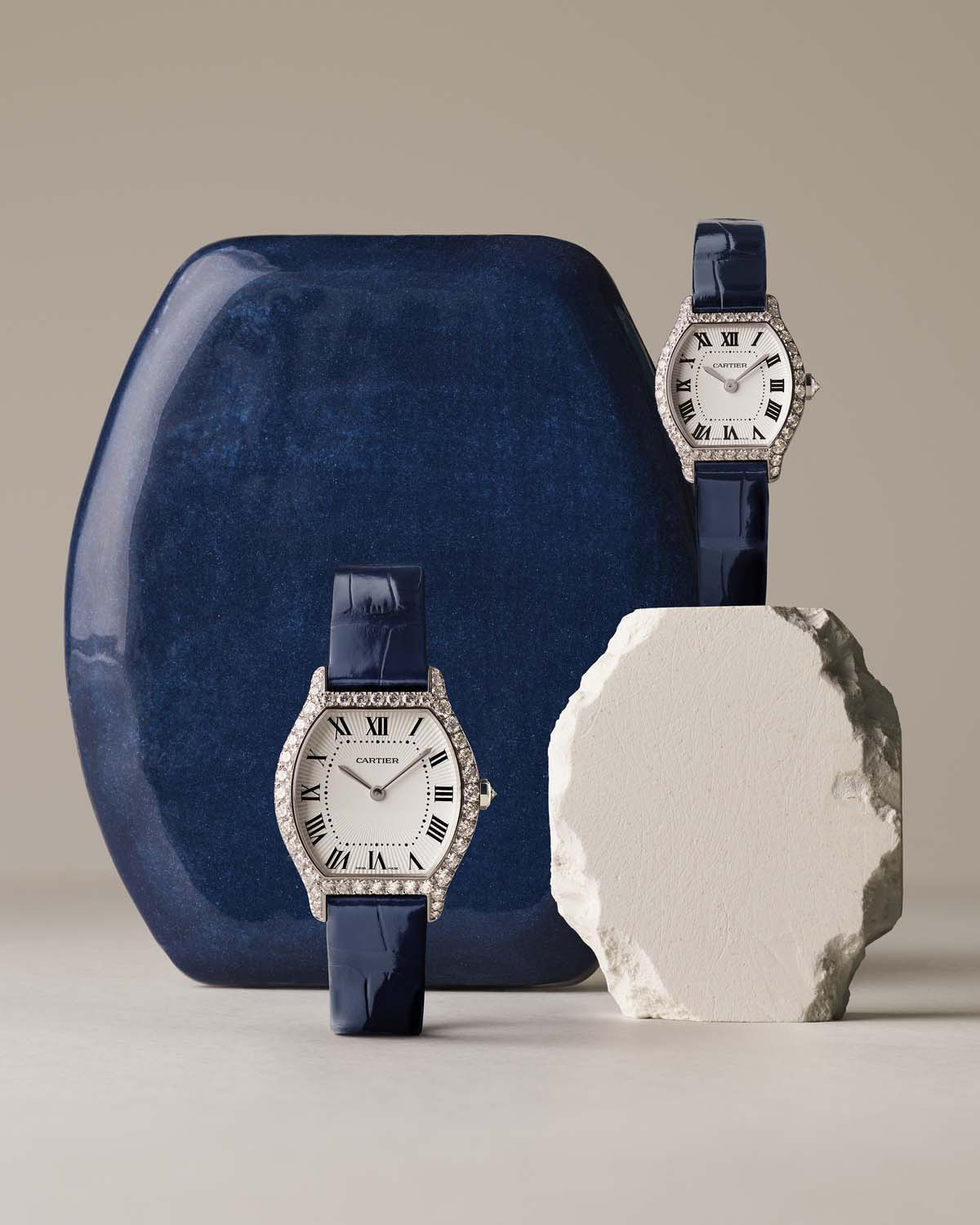 Dve diamantni uri Cartier Tortue z modrima paščkoma v postavitvi Watches and Wonders 2026