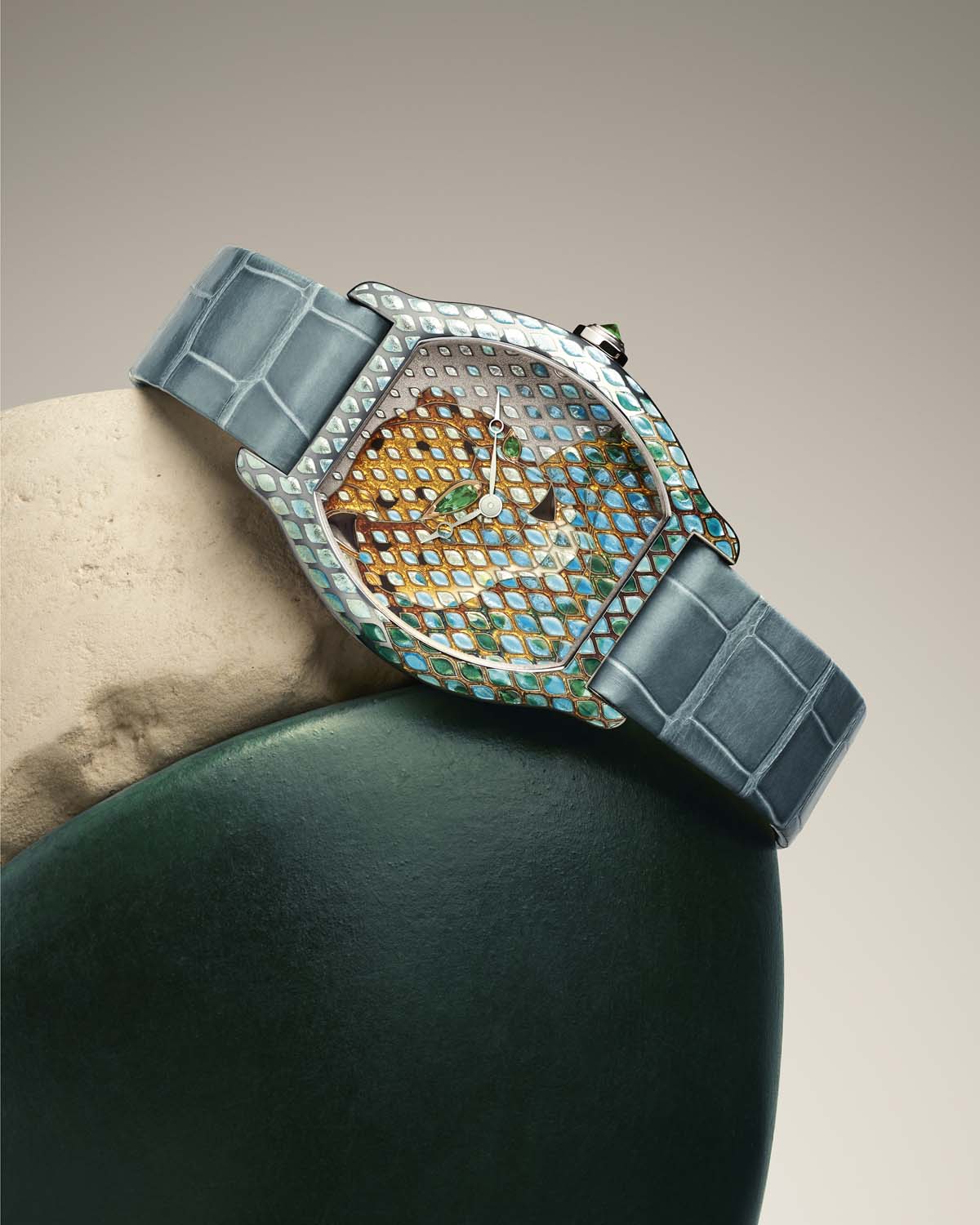Umetniška ura Cartier Tortue Panthère Métiers d’Art z modrim paščkom v dekorativni postavitvi
