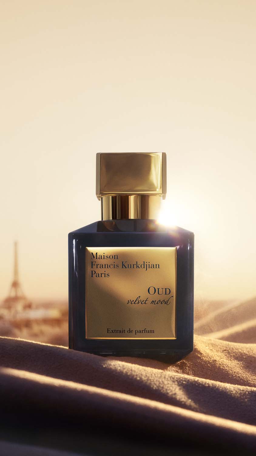 Steklenička parfuma Oud velvet mood na žametu s silhueto Pariza v ozadju